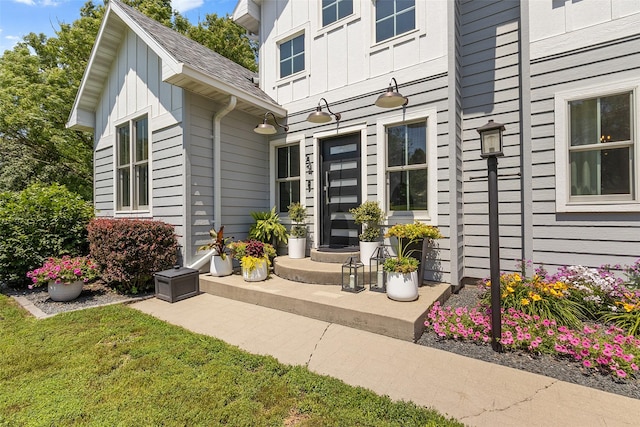 54 Four Winds Dr, Clear Lake, IA 50428 - view of exterior entry with board and batten siding and a lawn
