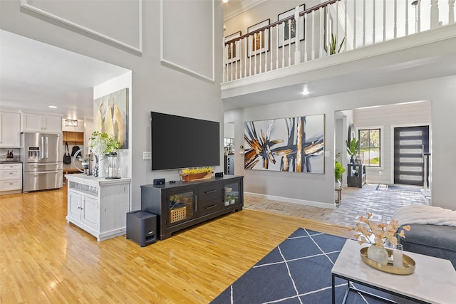 54 Four Winds Dr, Clear Lake, IA 50428 - living room featuring light wood finished floors, a high ceiling, crown molding, and recessed lighting