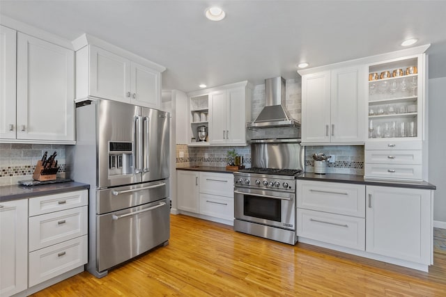 54 Four Winds Dr, Clear Lake, IA 50428 - kitchen featuring premium appliances, open shelves, wall chimney range hood, dark countertops, and decorative backsplash