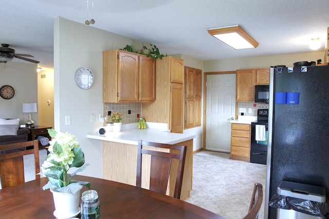 302 Crossing Ct NW, Bondurant, IA 50035 - kitchen featuring black appliances, decorative backsplash, light countertops, a peninsula, and a ceiling fan