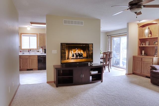 302 Crossing Ct NW, Bondurant, IA 50035 - living room featuring ceiling fan, light carpet, light tile patterned flooring, and a textured ceiling