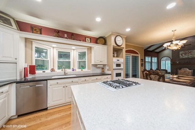 7100 Holcomb Ave, Urbandale, IA 50322 - kitchen featuring white appliances, a chandelier, white cabinetry, light wood-style floors, and vaulted ceiling
