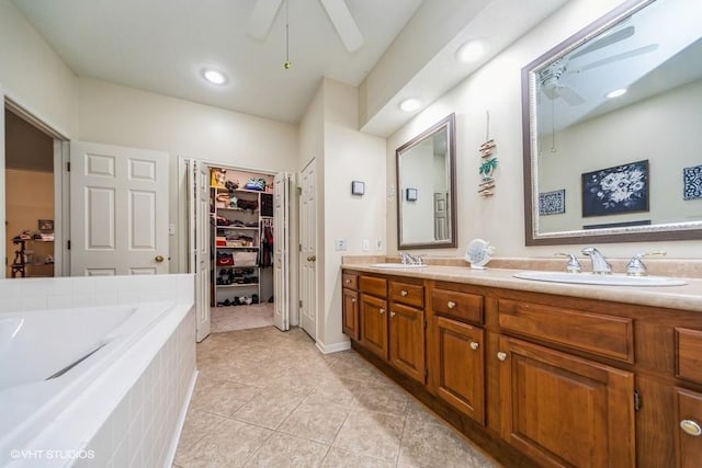 7100 Holcomb Ave, Urbandale, IA 50322 - full bath with a ceiling fan, double vanity, a garden tub, a spacious closet, and tile patterned floors