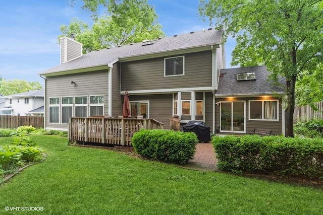 7100 Holcomb Ave, Urbandale, IA 50322 - back of property featuring a chimney, a deck, a shingled roof, and a patio