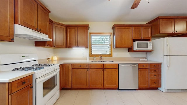 4610 SE 7th St, Des Moines, IA 50315 - kitchen with white appliances, under cabinet range hood, and brown cabinets