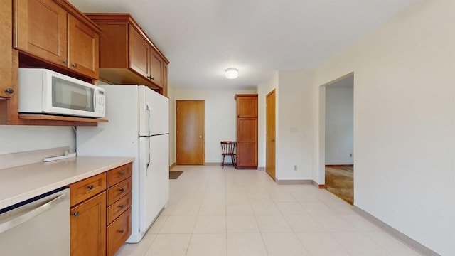 4610 SE 7th St, Des Moines, IA 50315 - kitchen featuring white appliances, brown cabinetry, and light countertops