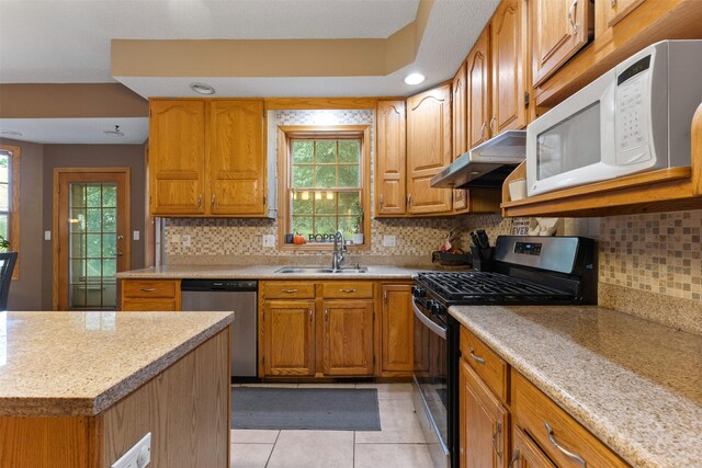 2400 Ridgetop Cir, Ames, IA 50014 - kitchen featuring stainless steel appliances, under cabinet range hood, light countertops, and light tile patterned floors