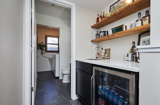 5208 Pommel Pl, West Des Moines, IA 50265 - indoor wet bar featuring dark marble finish flooring, washing machine and clothes dryer, and beverage cooler