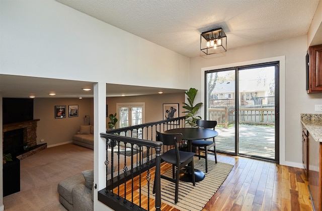 5208 Pommel Pl, West Des Moines, IA 50265 - dining area with a brick fireplace, a chandelier, a textured ceiling, light wood-style floors, and recessed lighting