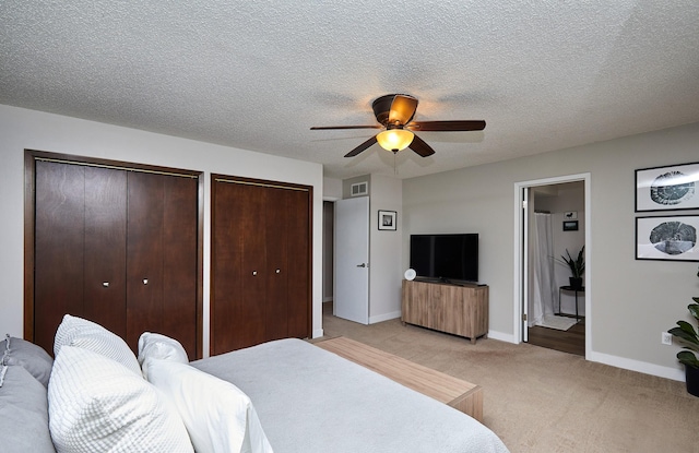 5208 Pommel Pl, West Des Moines, IA 50265 - bedroom with two closets, light colored carpet, a ceiling fan, ensuite bathroom, and a textured ceiling