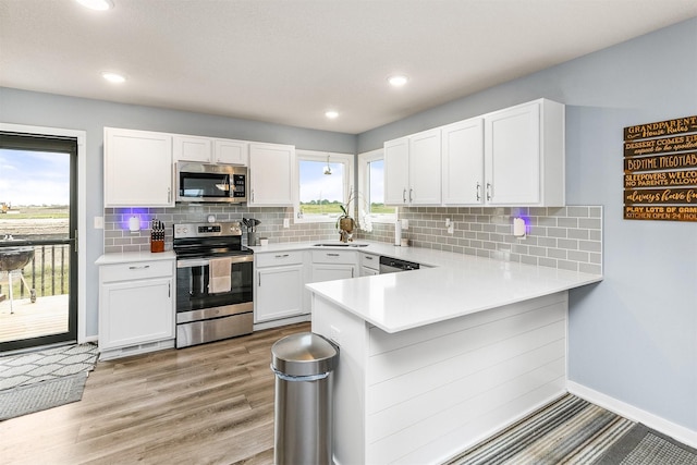 1115 Locust St, Waukee, IA 50263 - kitchen with stainless steel appliances, plenty of natural light, light countertops, white cabinetry, and recessed lighting
