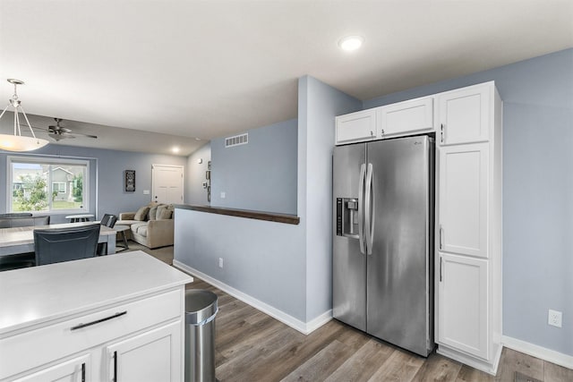 1115 Locust St, Waukee, IA 50263 - kitchen with stainless steel fridge, light wood finished floors, white cabinets, a ceiling fan, and recessed lighting