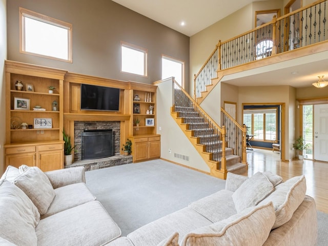 15815 Winston Ave, Urbandale, IA 50323 - living room with a towering ceiling, stairway, a stone fireplace, and recessed lighting