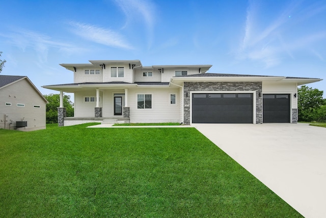 1310 NW Alderleaf Dr, Waukee, IA 50263 - view of front of home with an attached garage, a front lawn, concrete driveway, a porch, and stone siding