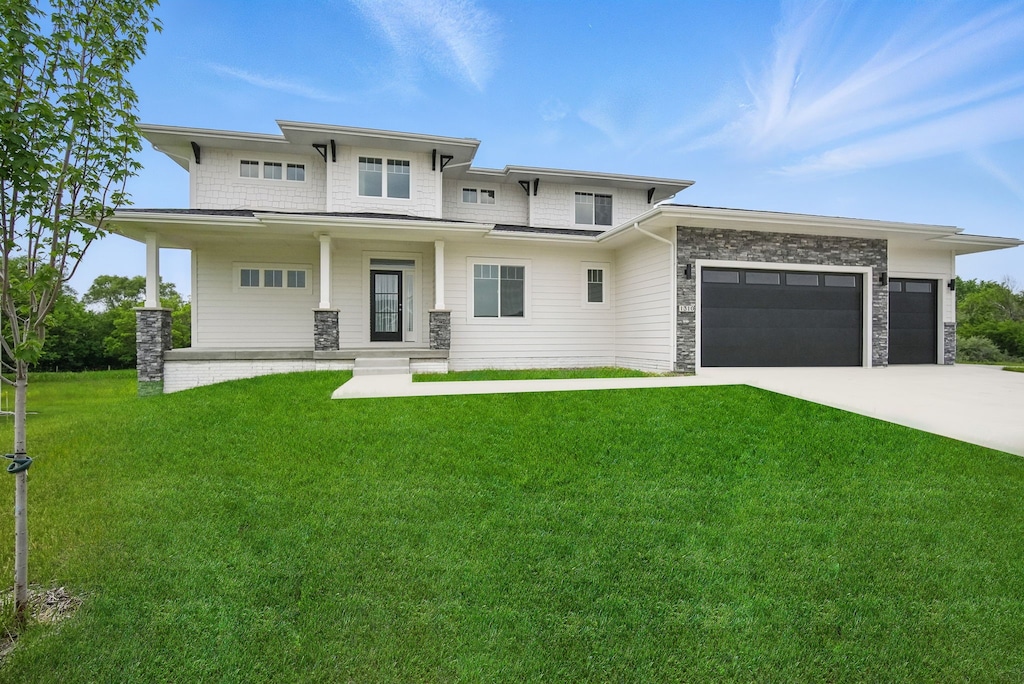 1310 NW Alderleaf Dr, Waukee, IA 50263 - prairie-style home with a front yard, an attached garage, stone siding, and covered porch