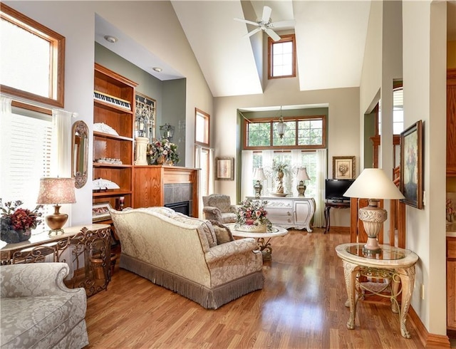 1699 Glade Dr SW, Altoona, IA 50009 - living room with high vaulted ceiling, a fireplace, a ceiling fan, and wood finished floors