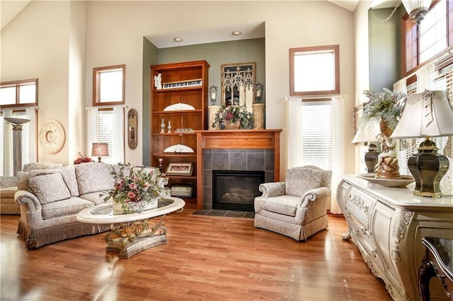 1699 Glade Dr SW, Altoona, IA 50009 - living room with high vaulted ceiling, a tiled fireplace, and light wood-style flooring