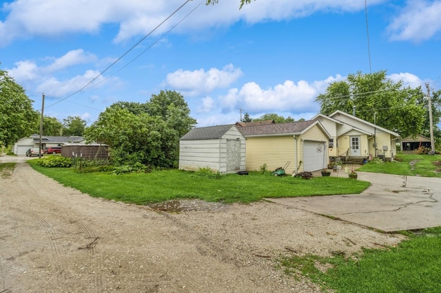 105 N St, Guthrie Center, IA 50115 - view of side of property with driveway, a shed, a garage, and a lawn