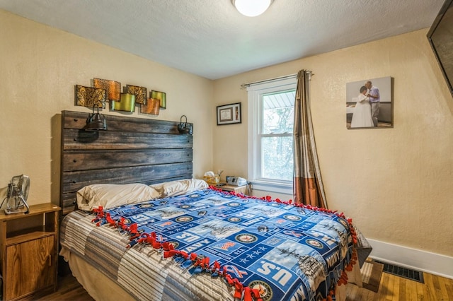105 N St, Guthrie Center, IA 50115 - bedroom with wood finished floors and a textured wall