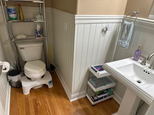 4017 160th St, Urbandale, IA 50323 - bathroom featuring a decorative wall, wood finished floors, and wainscoting