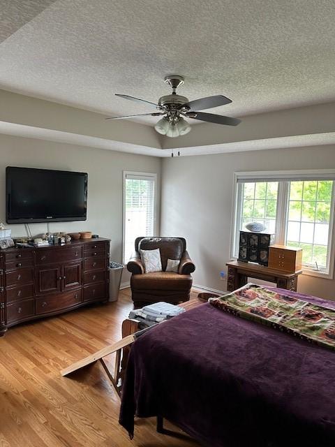 4017 160th St, Urbandale, IA 50323 - bedroom featuring a textured ceiling, light wood finished floors, and ceiling fan