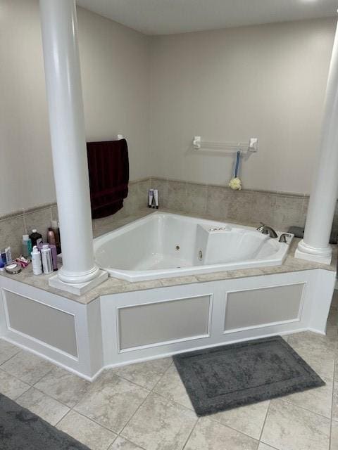 4017 160th St, Urbandale, IA 50323 - bathroom with ornate columns, a tub with jets, and tile patterned floors