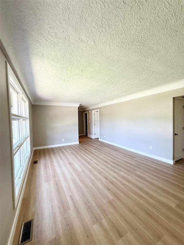 211 E Leach Ave, Des Moines, IA 50315 - unfurnished room with a textured ceiling and light wood-style flooring