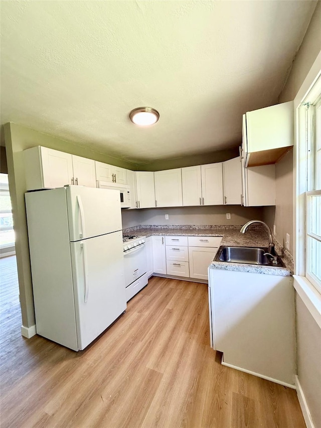 211 E Leach Ave, Des Moines, IA 50315 - kitchen with white appliances, light wood-type flooring, and white cabinets