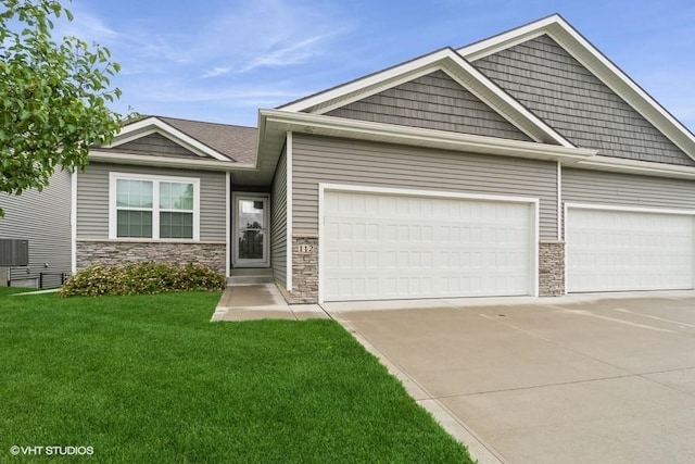 112 Hickory Way, Polk City, IA 50226 - craftsman house with stone siding, an attached garage, driveway, and a front lawn