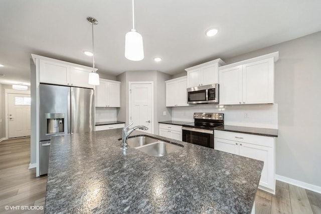 112 Hickory Way, Polk City, IA 50226 - kitchen featuring stainless steel appliances, a center island with sink, white cabinets, decorative backsplash, and recessed lighting