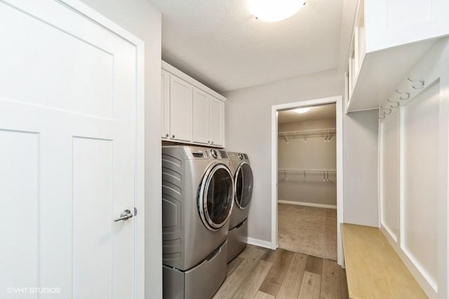 112 Hickory Way, Polk City, IA 50226 - washroom featuring washing machine and dryer, cabinet space, light wood-style flooring, and a textured ceiling