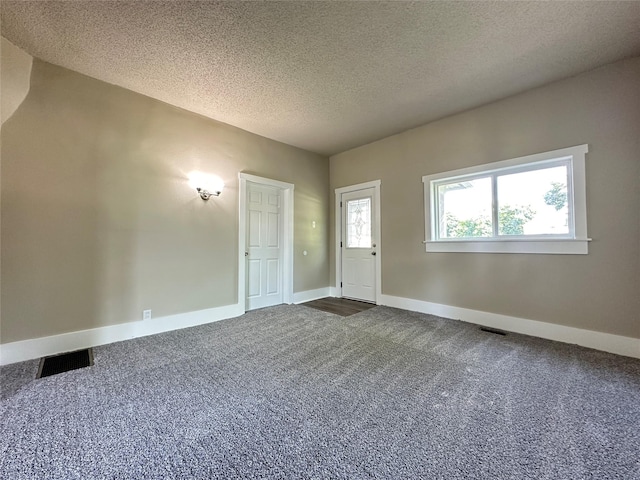 507 W Lincoln Way, Jefferson, IA 50129 - entryway with dark colored carpet and a textured ceiling