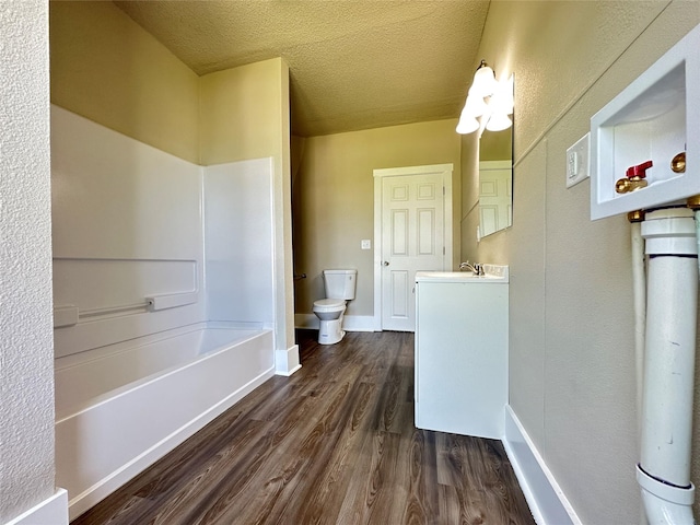507 W Lincoln Way, Jefferson, IA 50129 - full bath featuring wood finished floors, a tub to relax in, vanity, and a textured ceiling