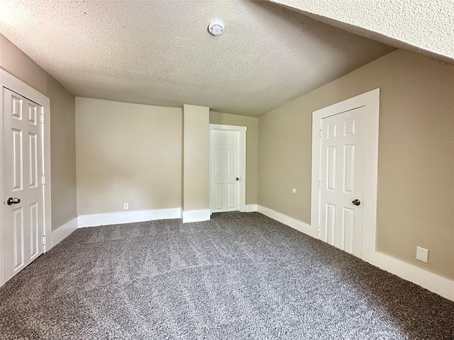 507 W Lincoln Way, Jefferson, IA 50129 - unfurnished bedroom featuring dark carpet and a textured ceiling
