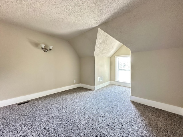 507 W Lincoln Way, Jefferson, IA 50129 - bonus room featuring a textured ceiling, carpet floors, and vaulted ceiling