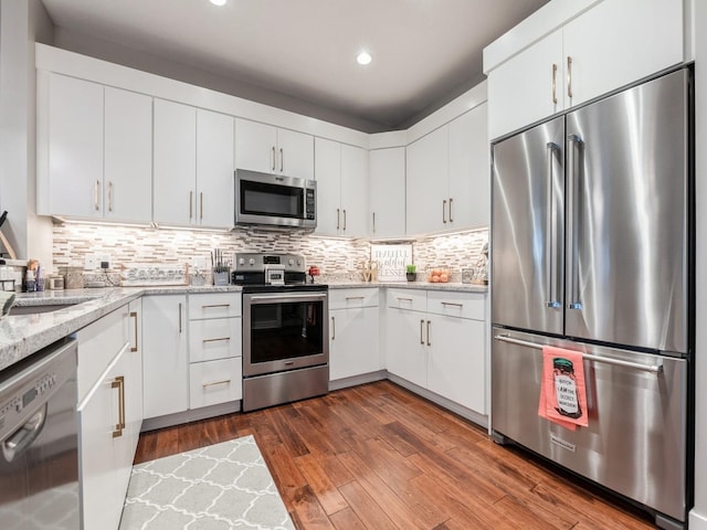 16530 Valleyview Ln, Clive, IA 50325 - kitchen with appliances with stainless steel finishes, recessed lighting, white cabinets, light stone counters, and tasteful backsplash