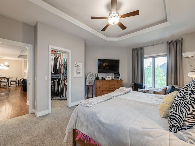 16530 Valleyview Ln, Clive, IA 50325 - bedroom featuring a tray ceiling, a spacious closet, a closet, a chandelier, and carpet