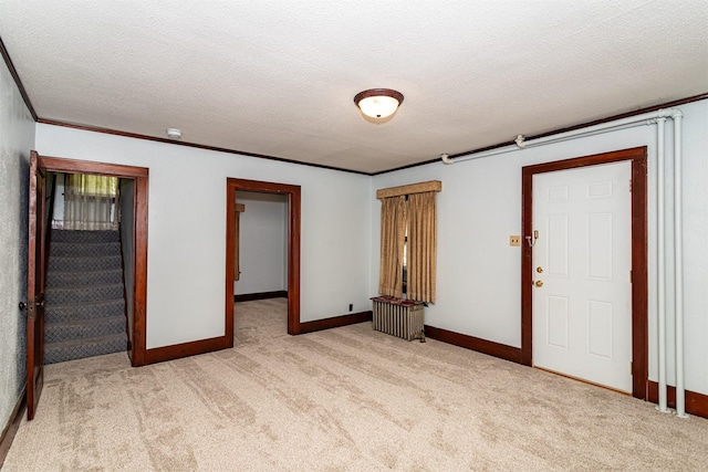 213 S Wilmoth Ave, Ames, IA 50014 - empty room with carpet flooring, radiator, a textured ceiling, stairway, and a smoke detector