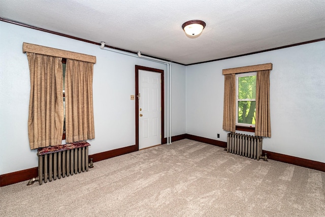 213 S Wilmoth Ave, Ames, IA 50014 - empty room with radiator heating unit, carpet floors, a textured ceiling, and ornamental molding
