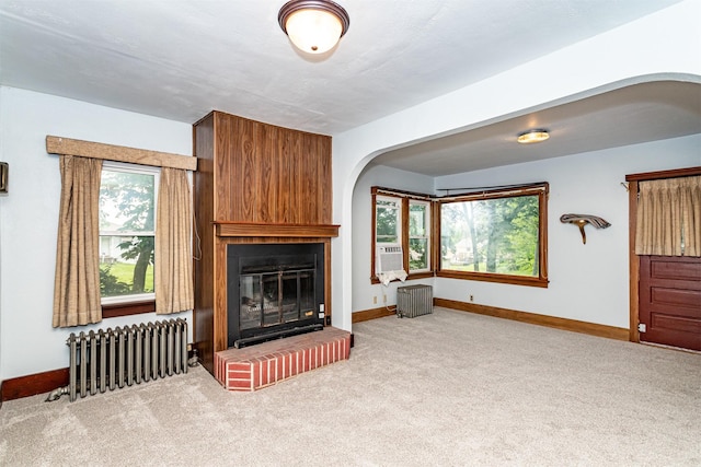 213 S Wilmoth Ave, Ames, IA 50014 - unfurnished living room with radiator, arched walkways, carpet, and a fireplace