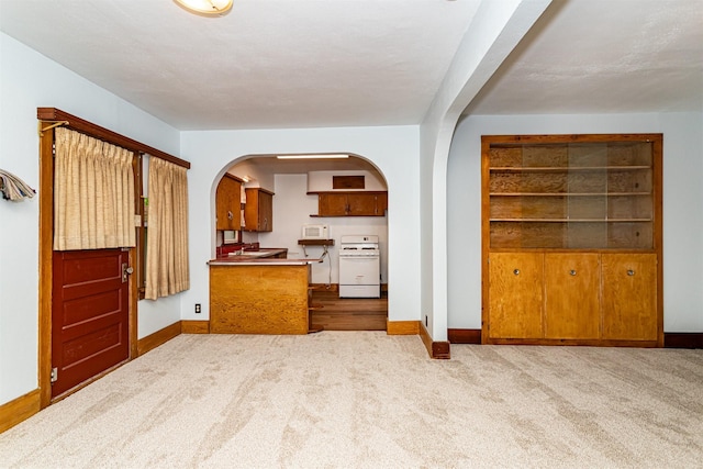 213 S Wilmoth Ave, Ames, IA 50014 - kitchen featuring gas range gas stove, arched walkways, carpet floors, and brown cabinets