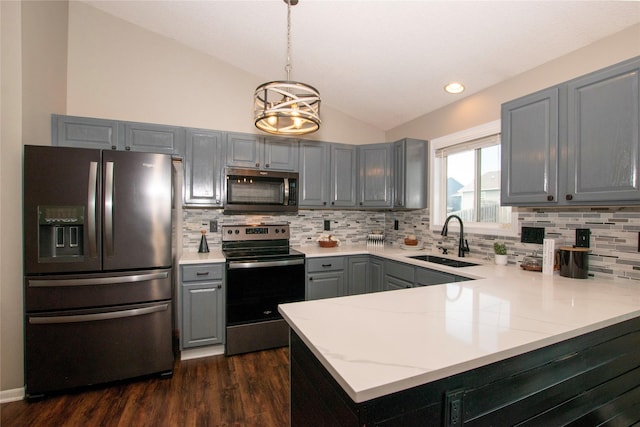 408 Tailfeather Ct NW, Bondurant, IA 50035 - kitchen featuring stainless steel appliances, gray cabinets, lofted ceiling, a peninsula, and backsplash