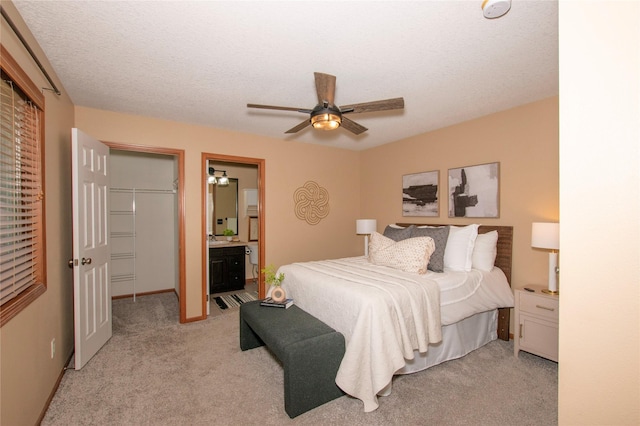 408 Tailfeather Ct NW, Bondurant, IA 50035 - bedroom featuring light colored carpet, a closet, a walk in closet, ensuite bath, and a ceiling fan