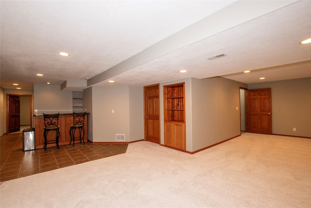 408 Tailfeather Ct NW, Bondurant, IA 50035 - unfurnished living room with recessed lighting, carpet flooring, tile patterned floors, and bar area