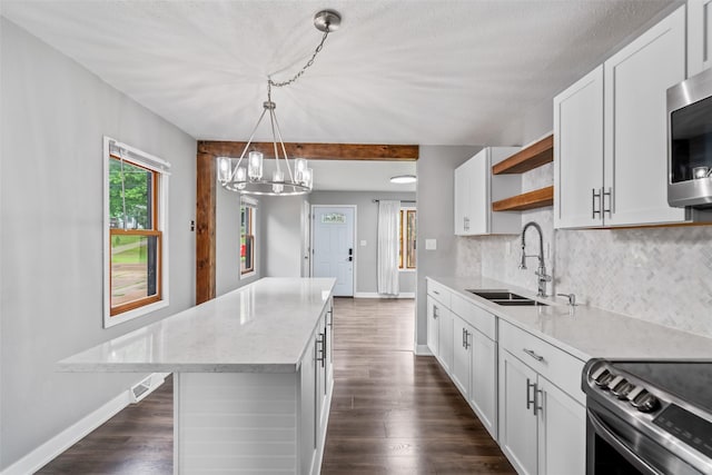 1115 E Herold Ave, Des Moines, IA 50315 - kitchen featuring open shelves, a chandelier, decorative backsplash, stainless steel appliances, and a kitchen island