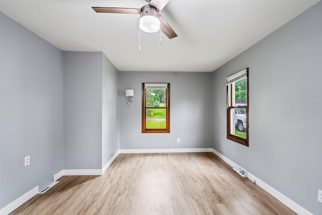 1115 E Herold Ave, Des Moines, IA 50315 - unfurnished room with wood finished floors, healthy amount of natural light, a ceiling fan, and a textured ceiling