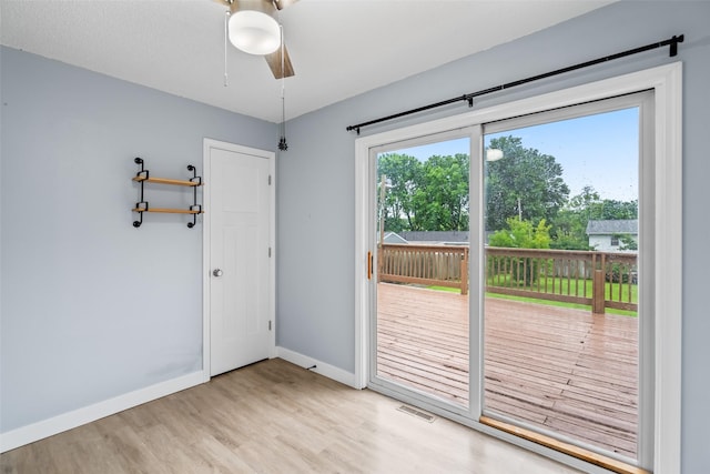 1115 E Herold Ave, Des Moines, IA 50315 - doorway to outside with light wood finished floors and ceiling fan