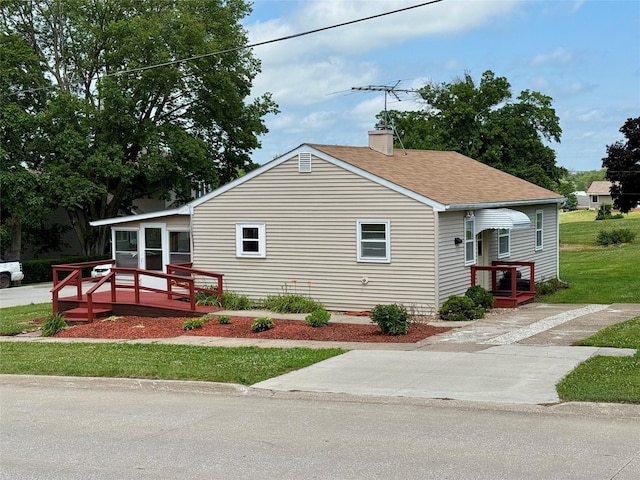 203 N Mill St, North English, IA 52316 - view of front of property with a chimney, a deck, and a shingled roof