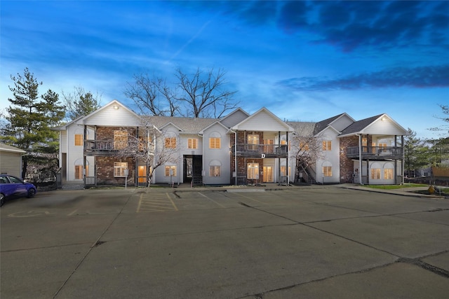 2547 Patricia Dr, Urbandale, IA 50322 - view of property featuring a balcony, uncovered parking, and brick siding