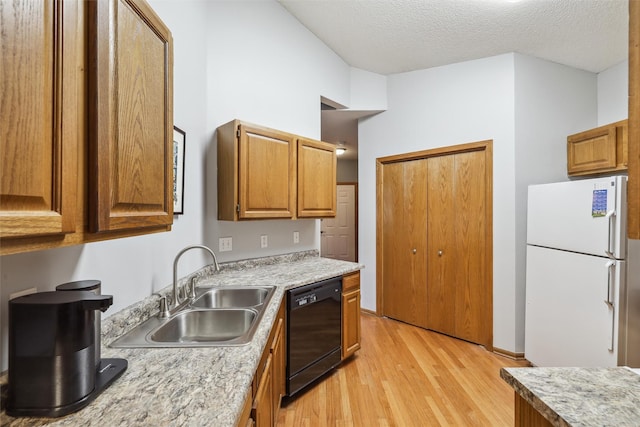 2547 Patricia Dr, Urbandale, IA 50322 - kitchen featuring freestanding refrigerator, black dishwasher, light wood-type flooring, light countertops, and brown cabinetry